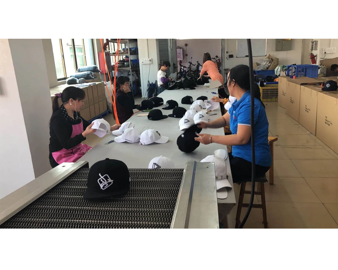 Quality control team inspecting finished baseball caps